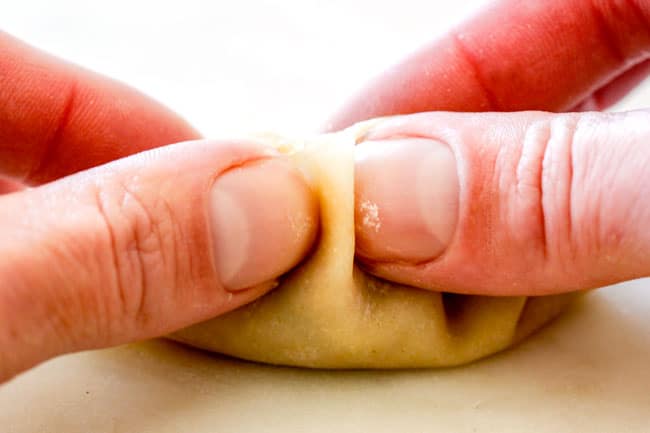 showing how to seal potstickers with pleats by making fourth pleat by pinching dough together