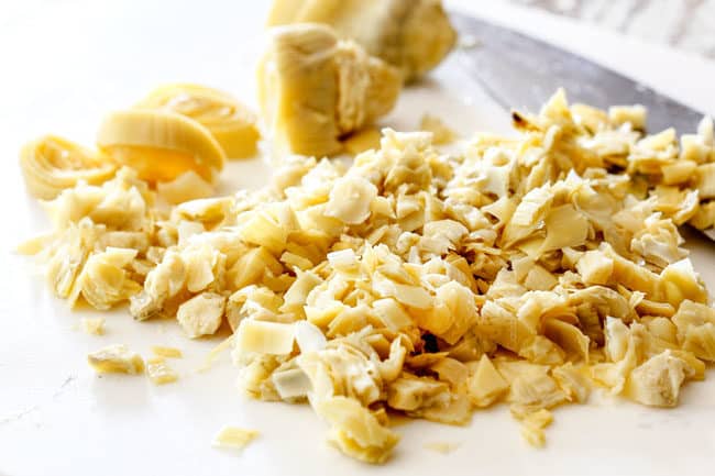 showing how to make spinach chicken lasagna by chopping artichokes