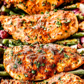up close front view of front view of honey mustard chicken and potatoes in a blue baking dish