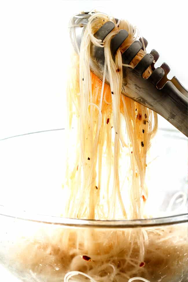 showing how to make Vietnamese Noodles by tossing rice noodles with dressing
