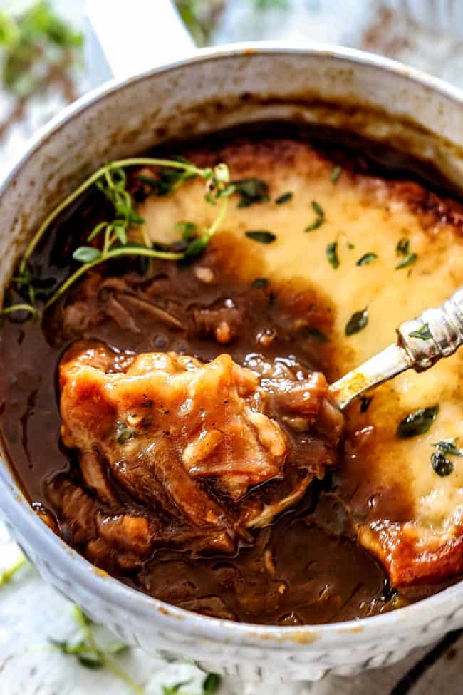 up close of a bowl of easy French Onion Soup with a bowl resting in the soup with cheesy bread