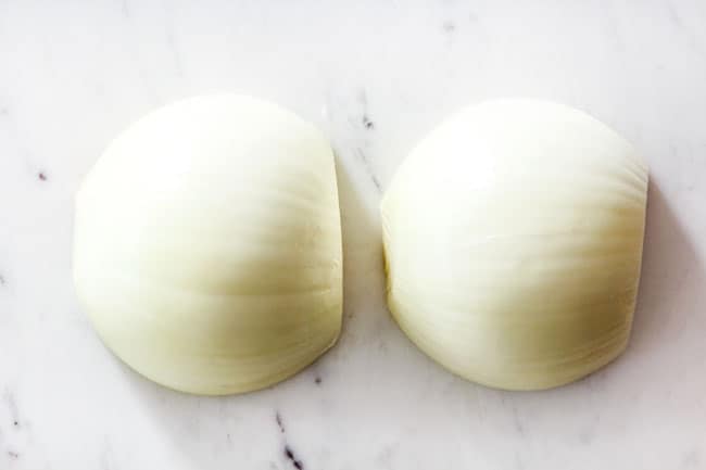 showing how to cut onions for French Onion Soup by slicing onions in half