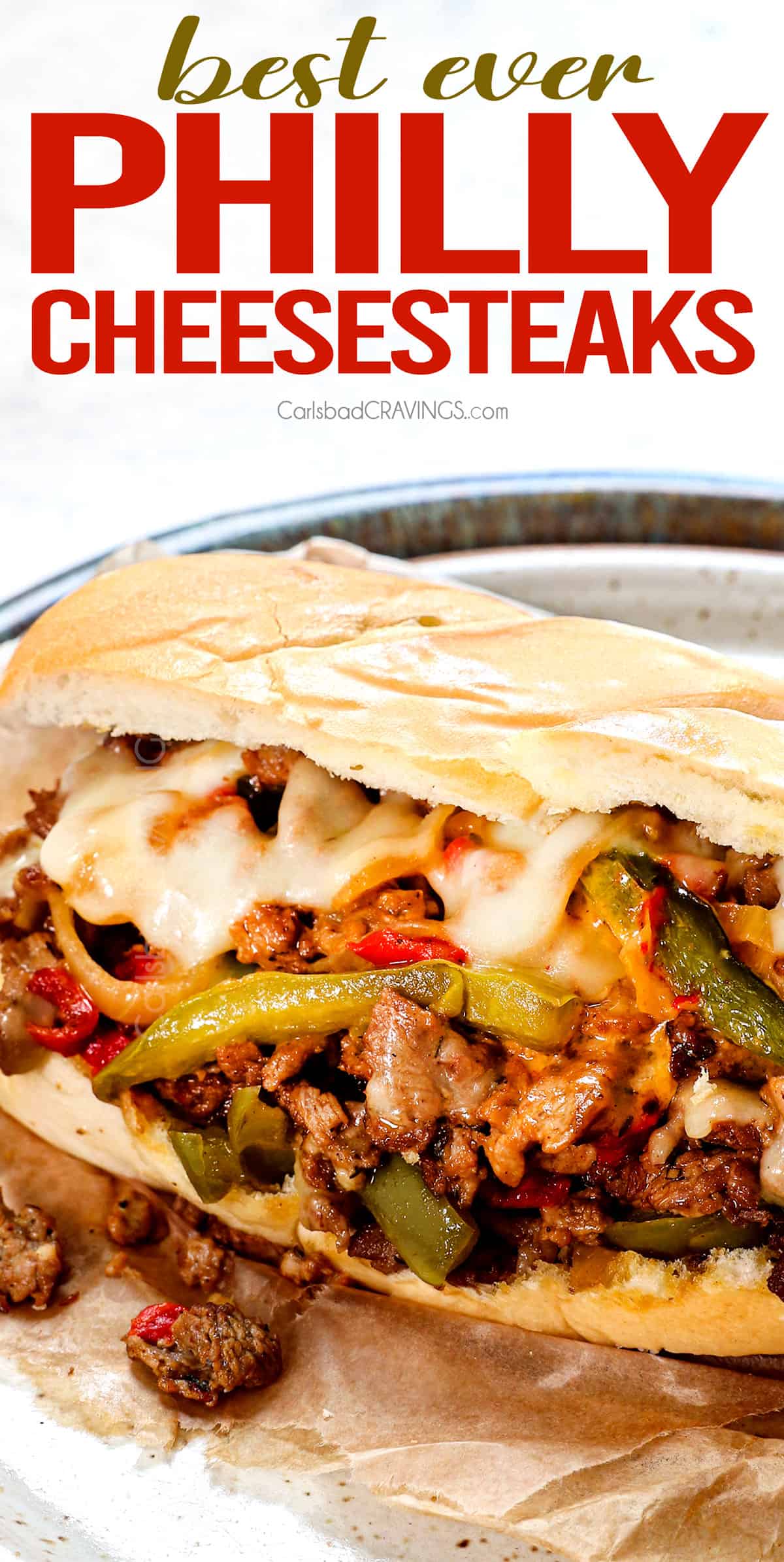 up close of Best Philly Cheesesteak recipe with a hand holding the Philly Cheesesteak with steak and peppers falling out