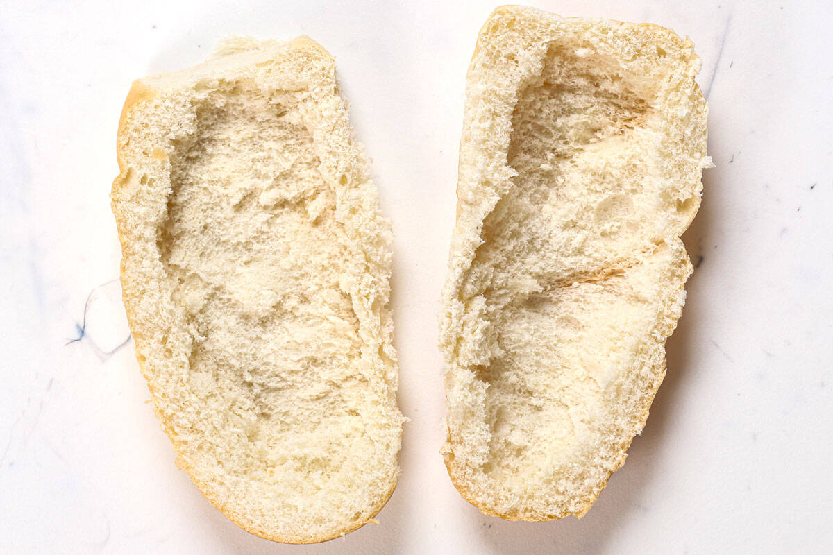 showing how to make Philly cheesesteak by hollowing out the hoagie rolls