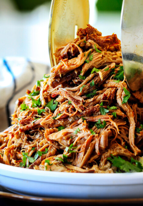 two tongs picking up some slow cooker pork for pork fajitas recipe