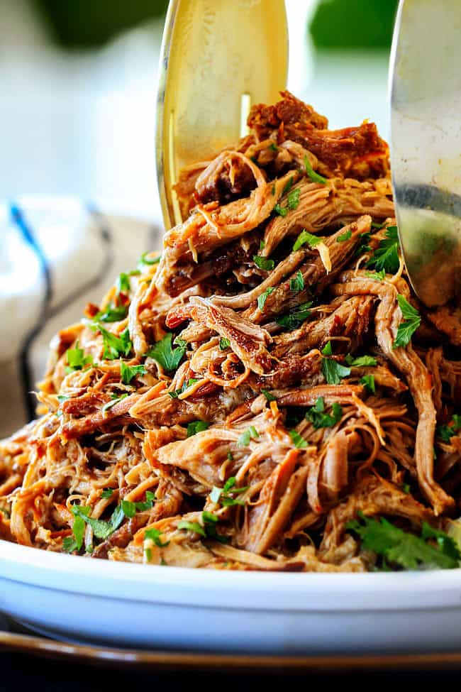 two tongs picking up some slow cooker pork for pork fajitas recipe