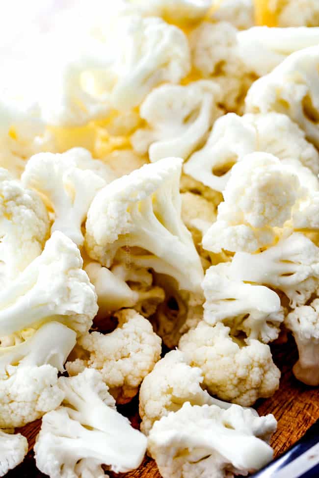 showing how to make roasted cauliflower by chopping cauliflower into uniform florets