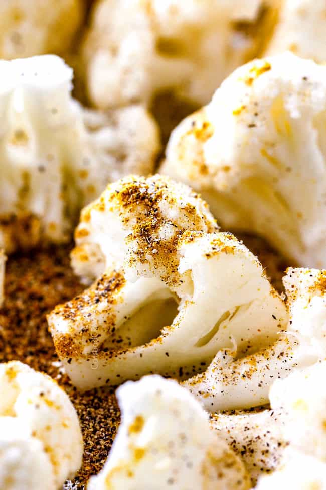 showing how to make roasted cauliflower by tossing with curry, salt and pepper