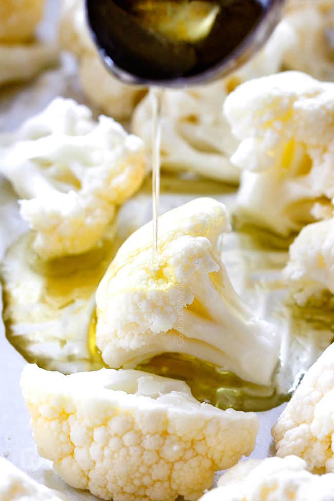 showing how to make roasted cauliflower by drizzling with olive oil