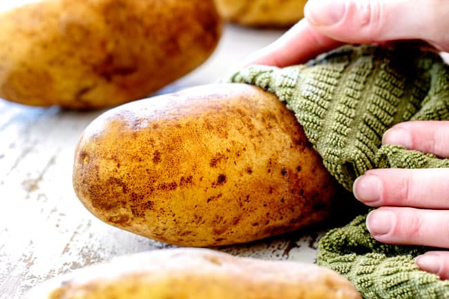 showing how to make twice baked potatoes by washing and drying potatoes with a green cloth