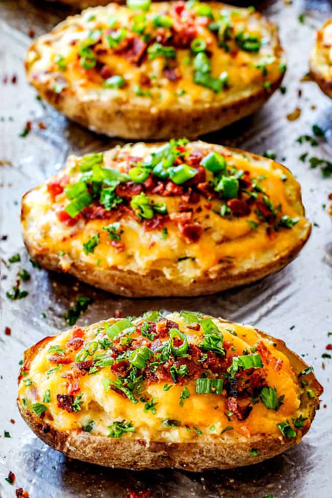 easy twice baked potatoes with sour cream, butter, cheese and bacon on a baking sheet