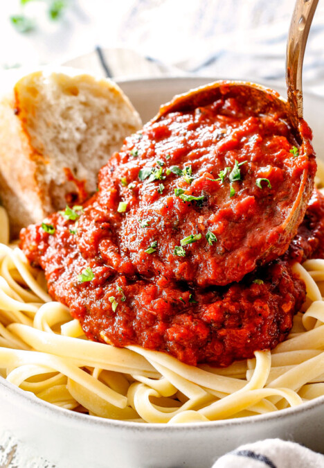 spooning marinara from scratch over noodles