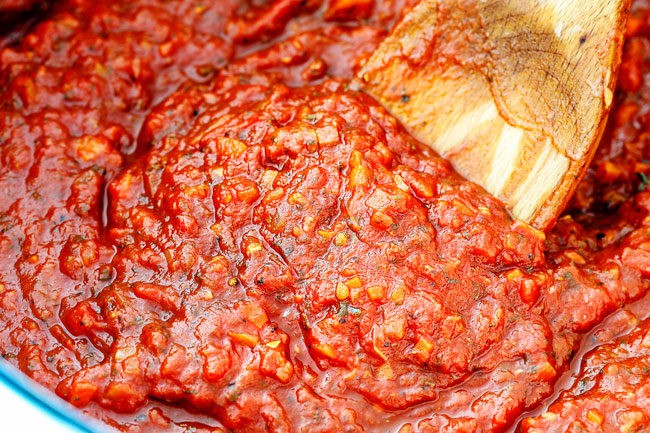 showing how to make manicotti by simmering homemade marinara sauce