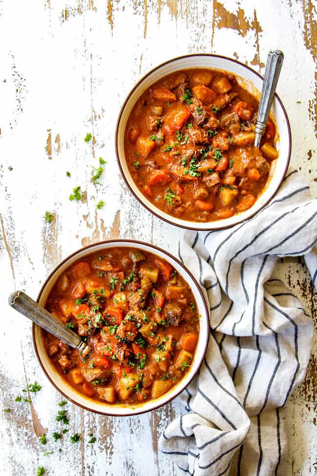 top view of old fashioned crockpot beef stew in two bowls garnished with parsley