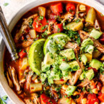 a bowl of authentic Caldo de pollo (Mexican Chicken Soup) toppd with avocadoes, cilantro and limes
