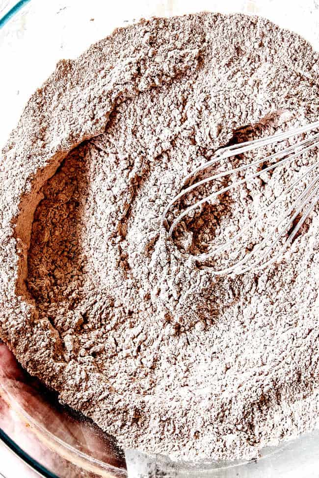 showing how to make make Chocolate Waffles by whisking together cocoa powder, flour, baking soda, baking powder, salt, cinnamon in a glass bowl