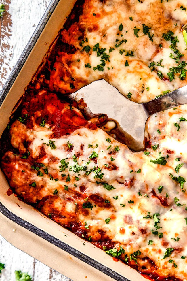 a silver spatula digging into best manicotti with marinara and mozzarella