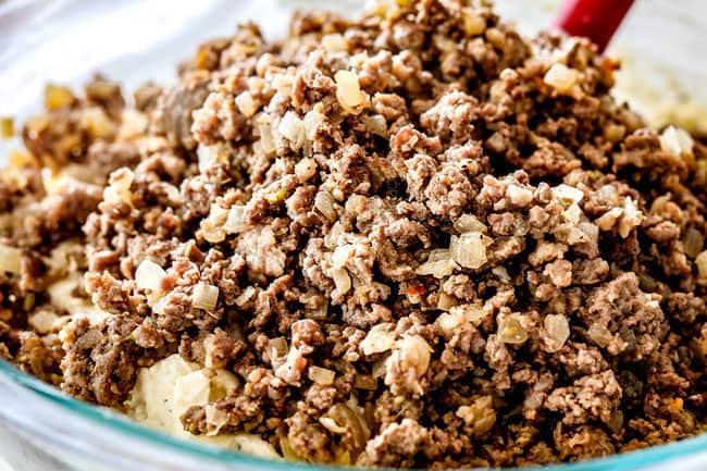 beef and sausage being stirred into ricotta to make filling for manicotti