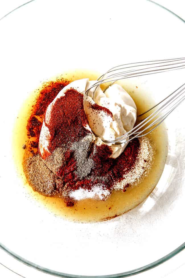 showing how to make enchiladas by adding green enchilada sauce, sour cream and spices to a glass bowl to make filling