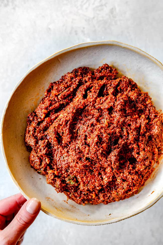 holding Greek Salad dressing with a hand