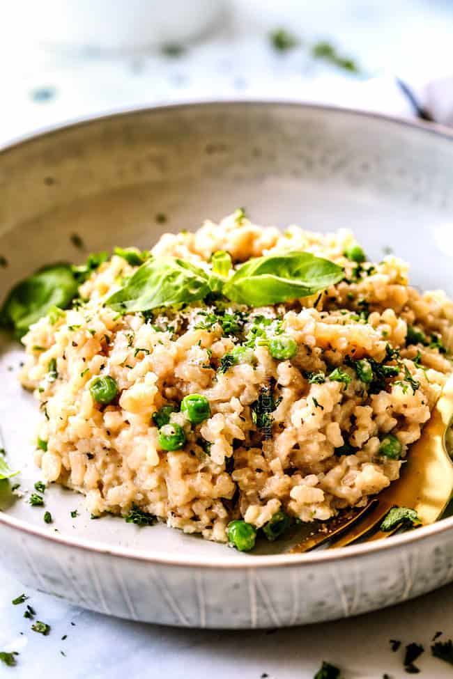 side view of easy Parmesan risotto recipe on a grey plate with a gold fork