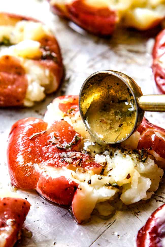showing how to make smashed potatoes by drizzling potatoes with butter and garlic