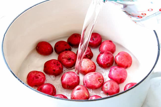 showing how to make smashed potatoes by adding water to a pot to boil red potatoes