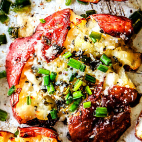 up close top view of roasted smashed potatoes with butter, garlic and chives