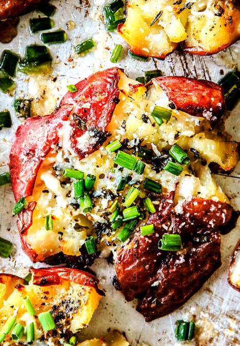 up close top view of roasted smashed potatoes with butter, garlic and chives