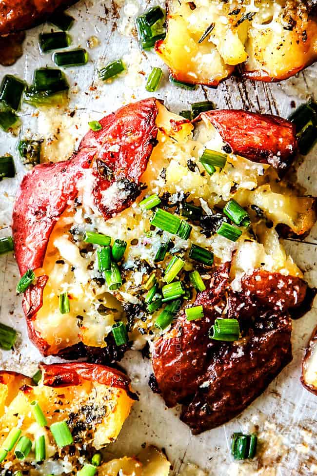 up close top view of roasted smashed potatoes with butter, garlic and chives