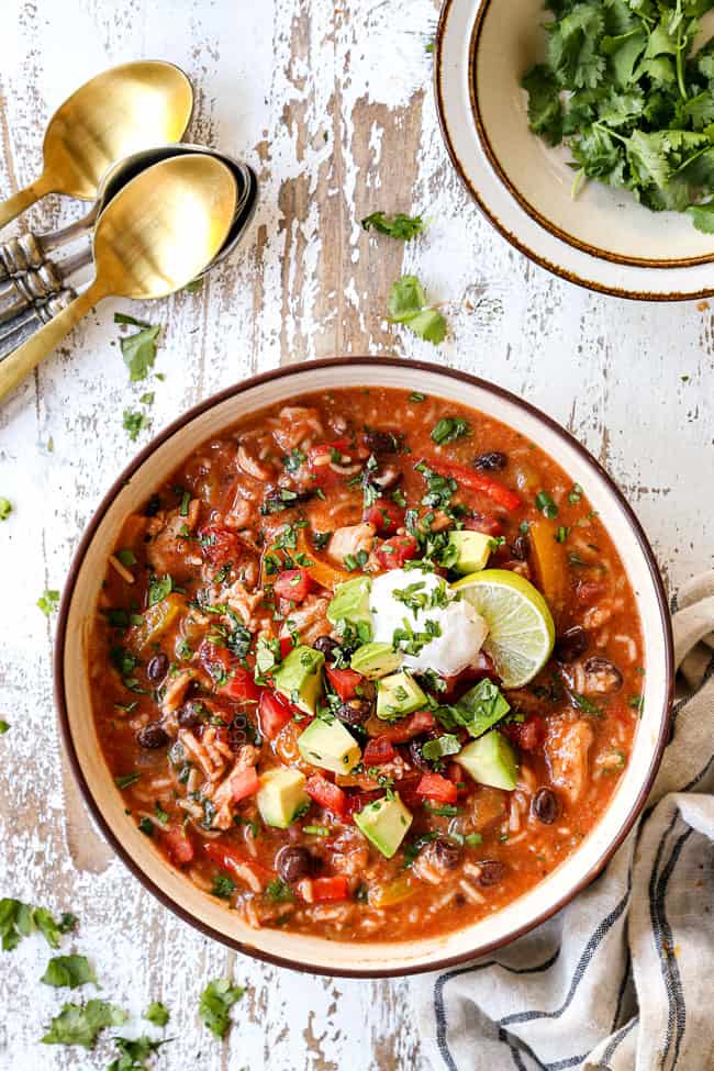 top view of chicken fajita soup garnished with tomatoes, sour cream and avocados