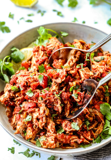two tongs picking up chipotle Mexican chicken