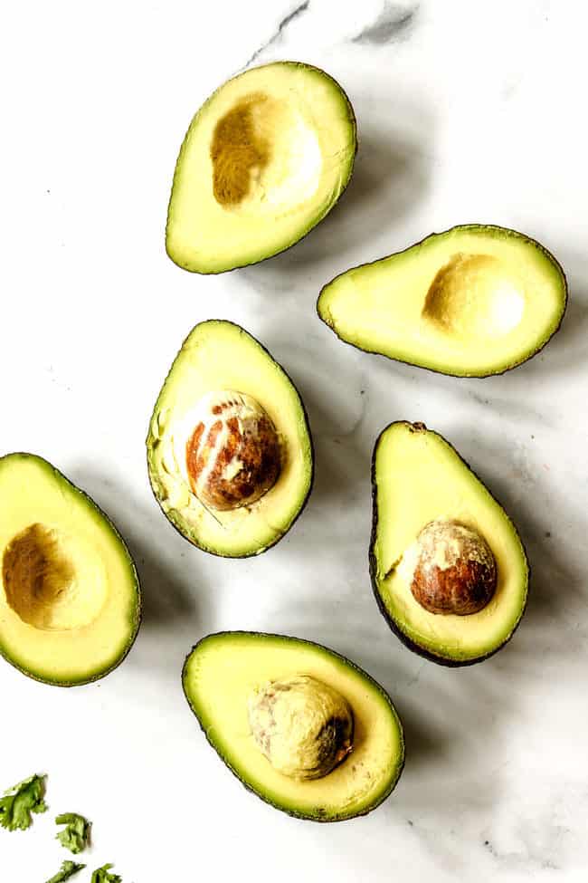 top view of ripe avocado cut in half on a marble counter showing what ripe avocados look like