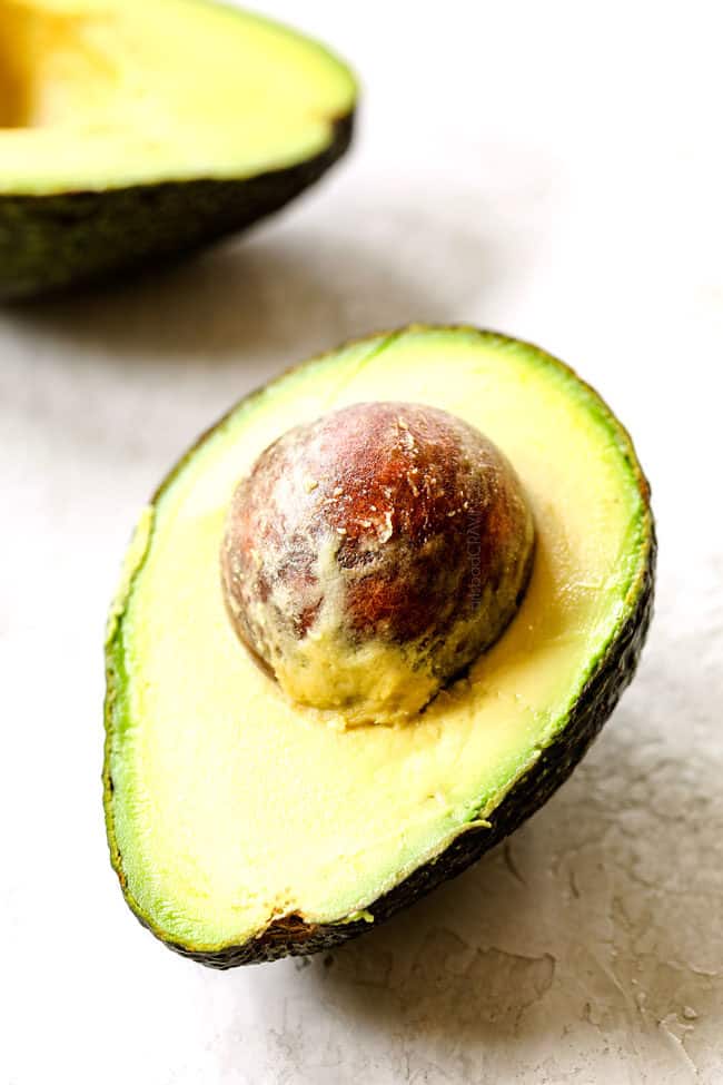 showing how to make shrimp avocado salad recipe by choosing a ripe mango