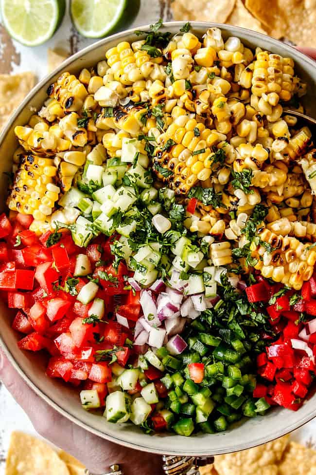 top view showing how to make corn salsa by adding corn, onions, tomatoes, bell peppers jalapenos, lime juice and cilantro to a bowl