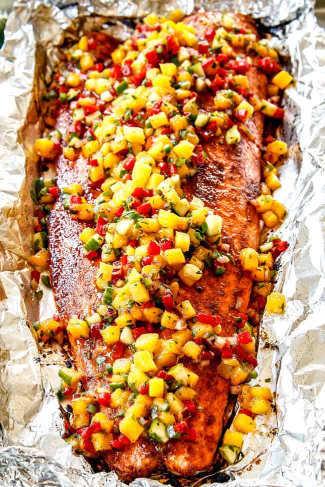 showing how to use mango salsa by adding it on top of salmon