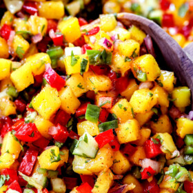 up close of two servings spoons scooping up mango salsa recipe