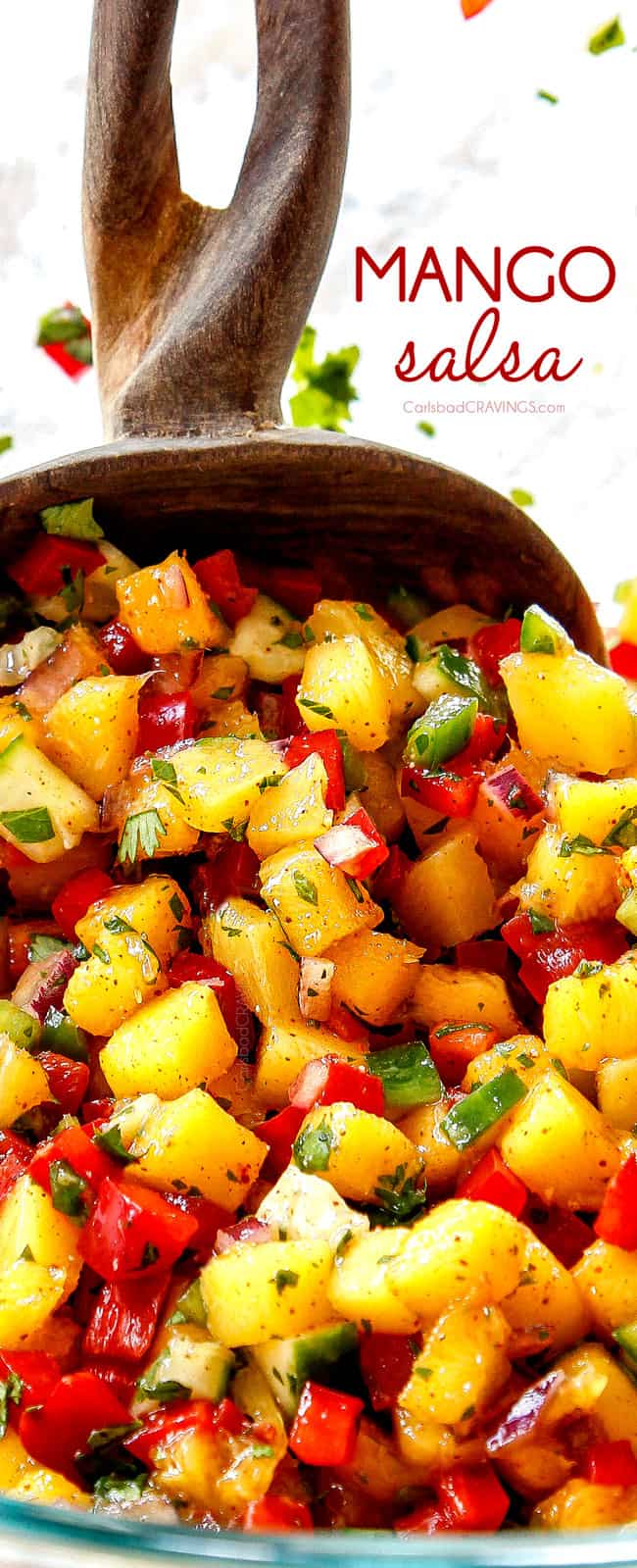 up close of two servings spoons scooping up mango salsa recipe