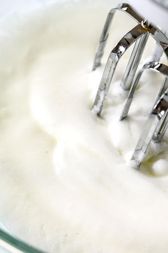 showing how to make strawberry shortcake cake by whipping egg whites until fluffy