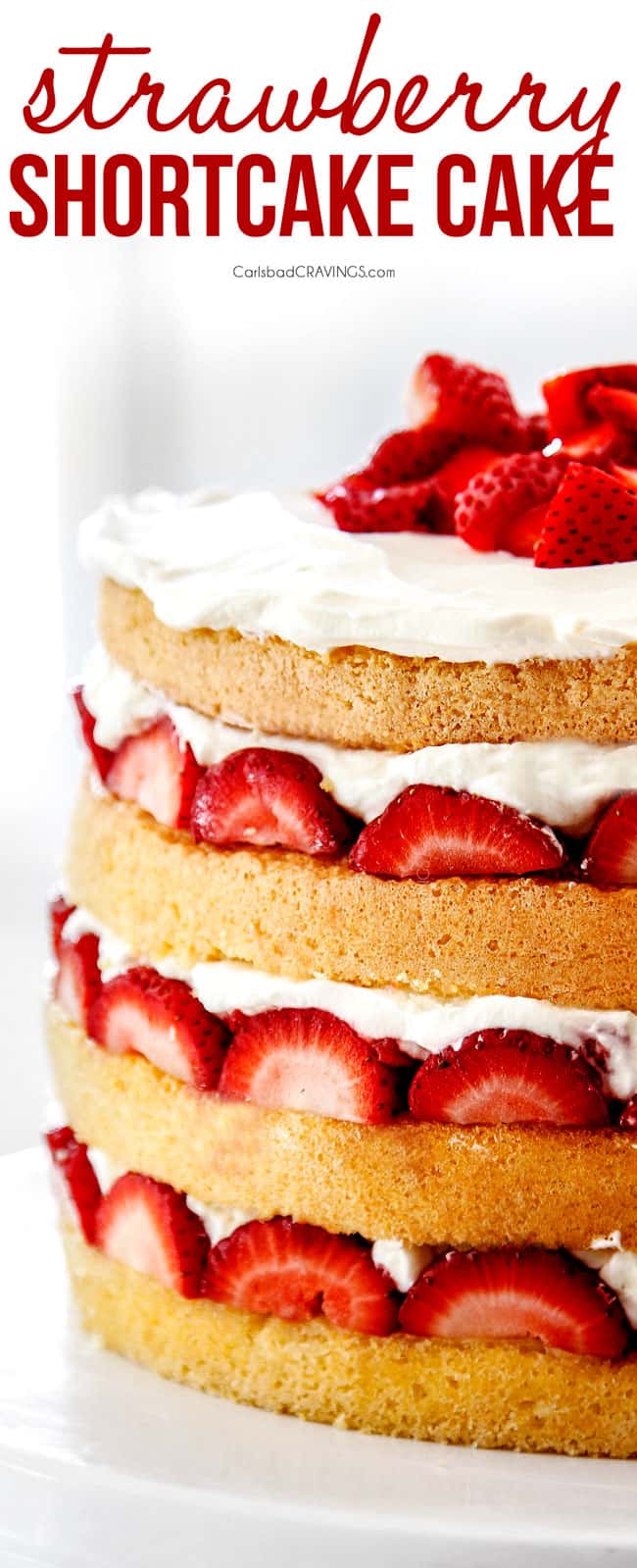 up close of strawberry shortcake cake with layers of sponge cake, strawberries and whipped cream