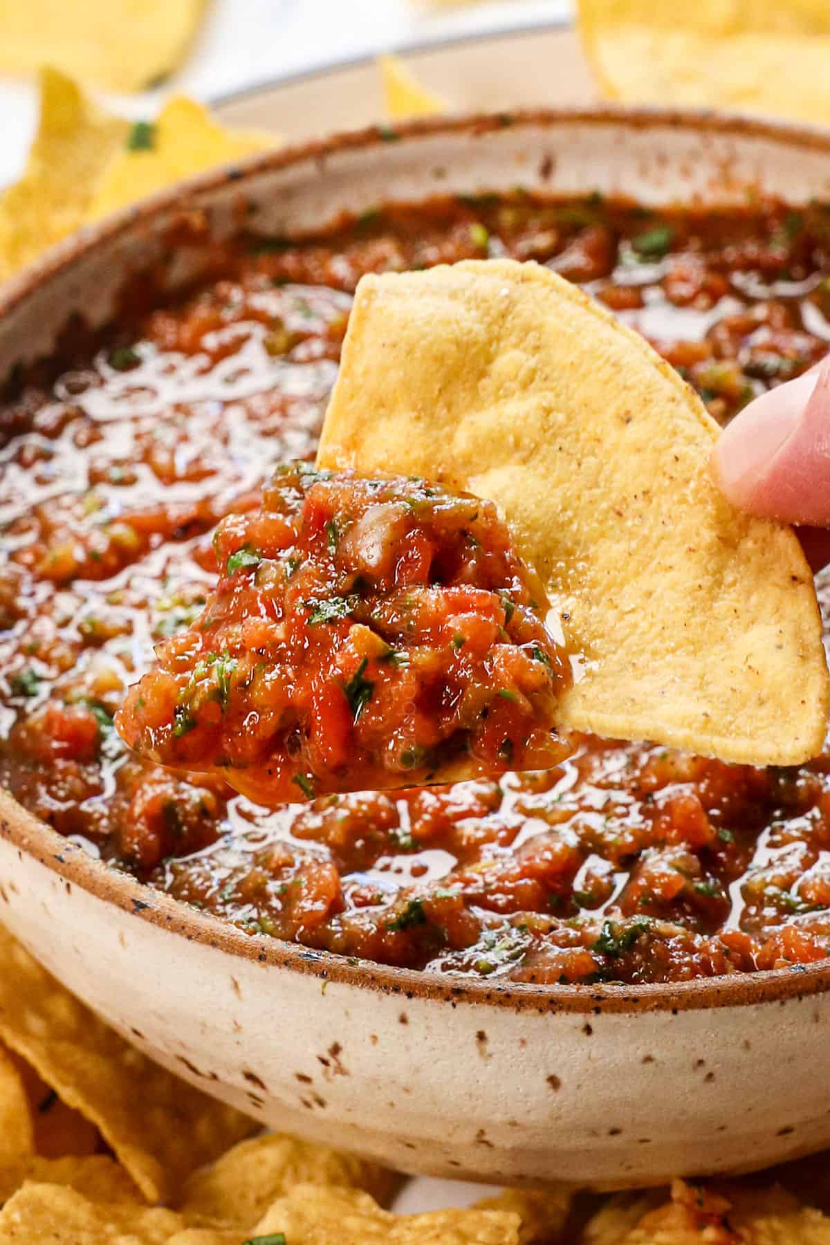dipping a chip in the best homemade salsa recipe