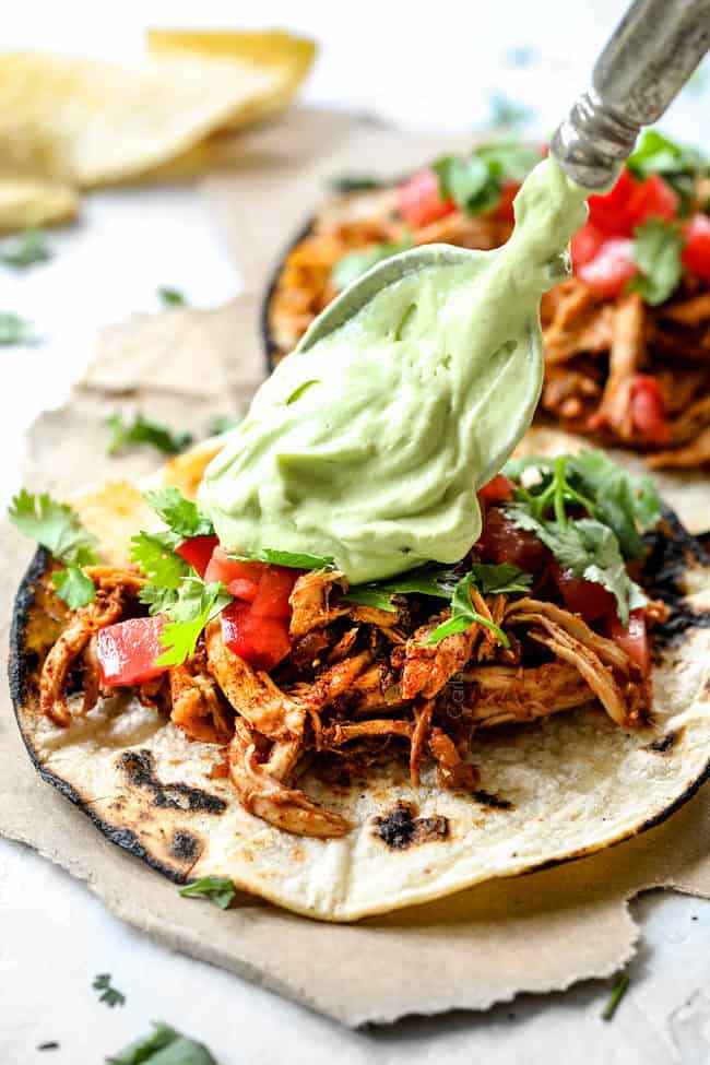 putting avocado crema on chicken tacos