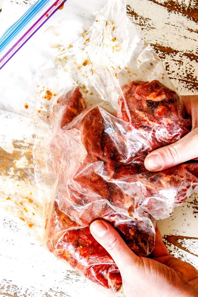 showing how to make Szechuan Beef by massaging marinadae into steak with hands