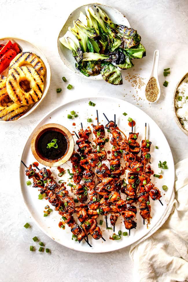 top view of yakitori recipe on a white platter with a side of yakitori sauce