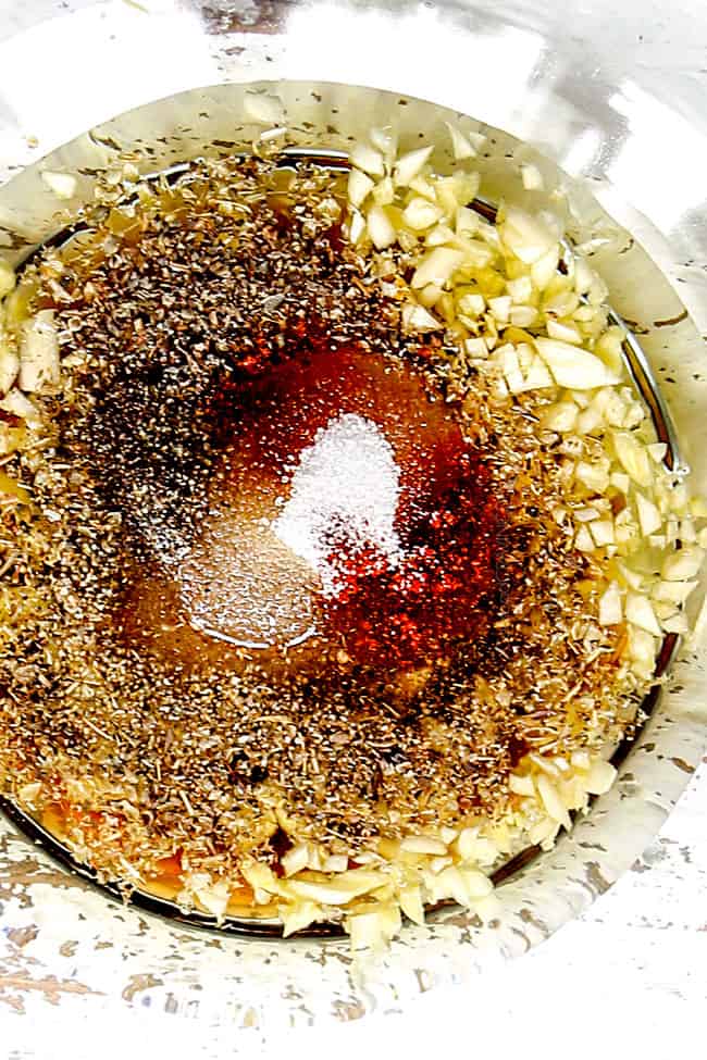 showing how to make chicken gyro recipe by adding Greek chicken marinade to a bowlr