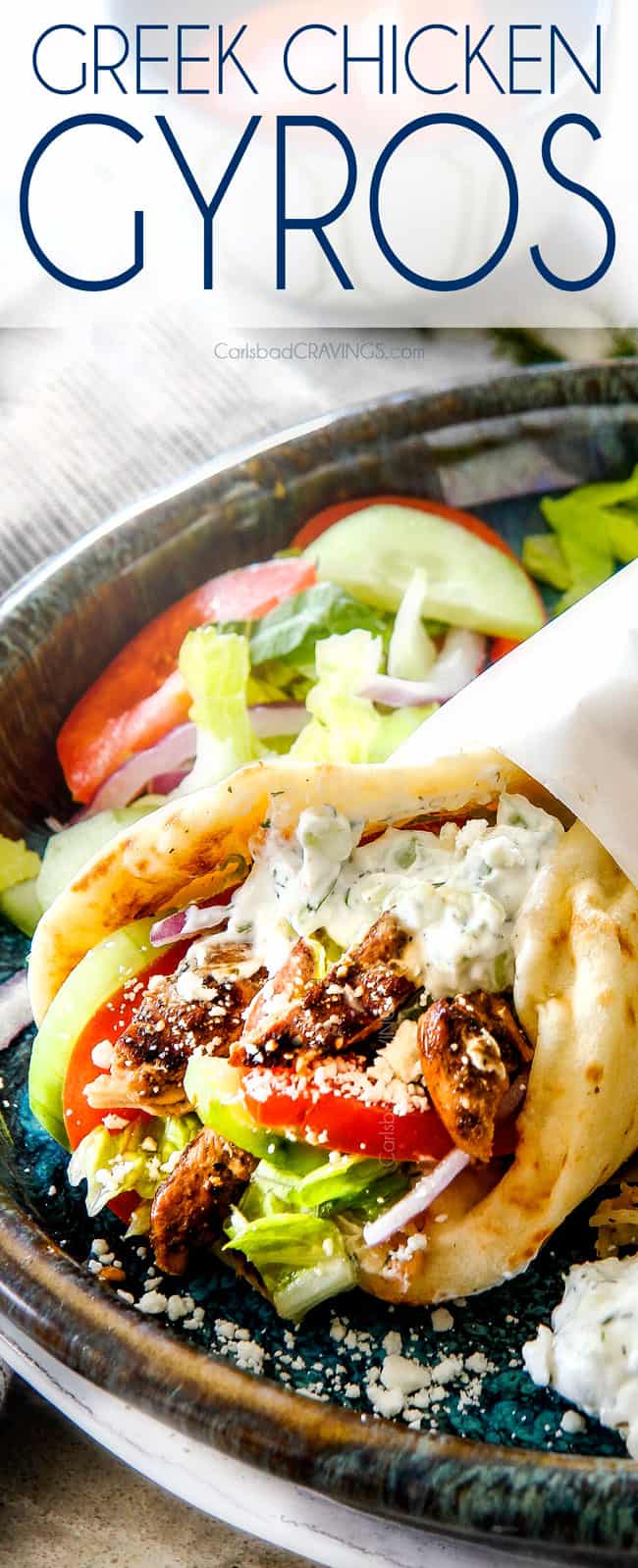 up close of a chicken gyro  with Greek chicken, tomatoes, lettuce and tzatziki wrapped in paper