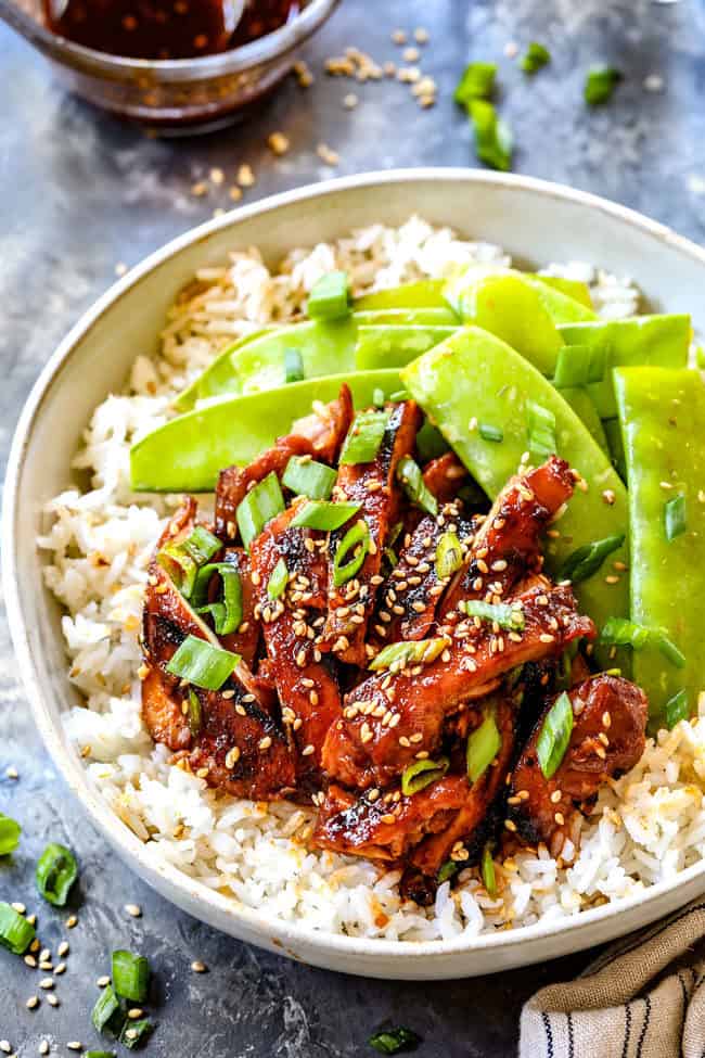 showing what sided to serve with Korean BBQ Chicken by placing chicken in a bowl with rice
