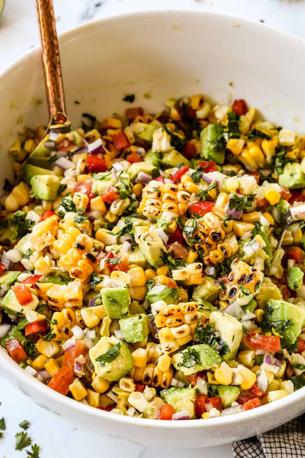showing how to make avocado corn salsa by picking ripe avocados