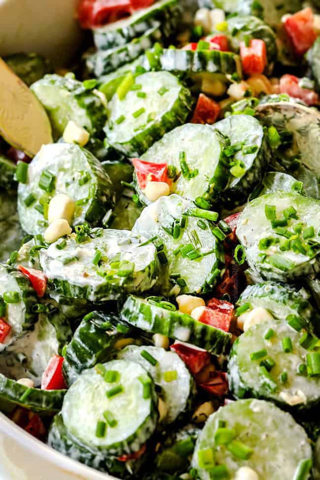 up close side view of creamy cucumber salad with sour cream, mayo and dill