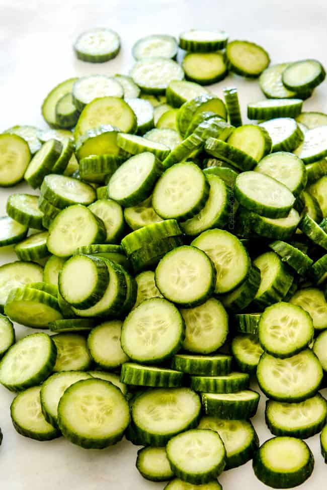 showing how to make creamy cucumber salad by slicing English cucumbers
